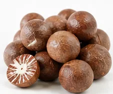 Tumpukan pinang bulat kering berwarna cokelat, satu di antaranya terbelah.